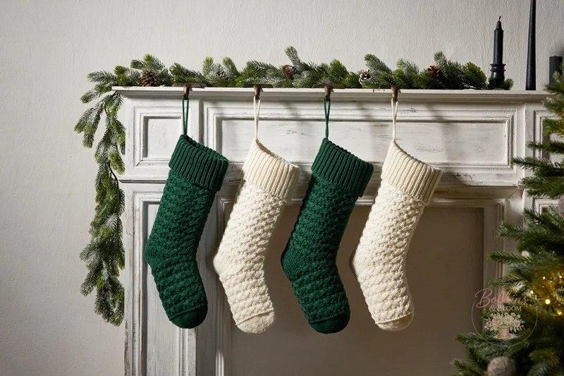 Green and cream heirloom knit Christmas stockings hanging on a mantel