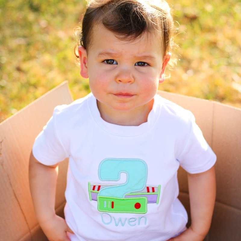 Toddler wearing an embroidered 2nd birthday shirt with a space ranger number applique