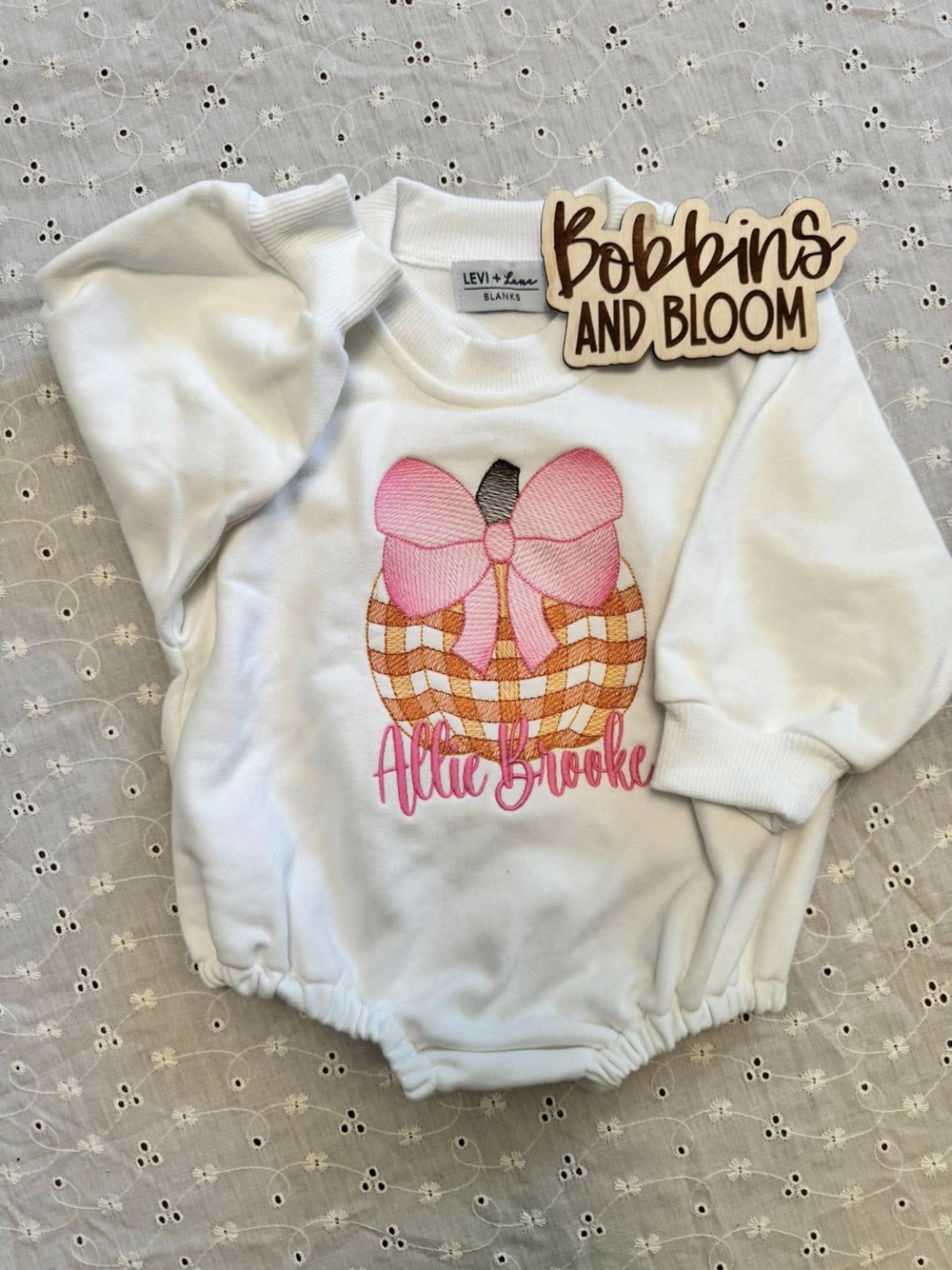 White knit sweatshirt bubble romper embroidered with a gingham pumpkin, pink bow, and the name Allie Brooke