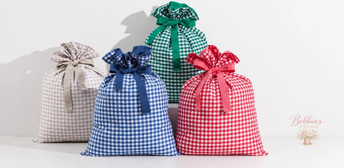 Gingham Santa gift bags in tan, blue, green, and red, each with a matching ribbon tie