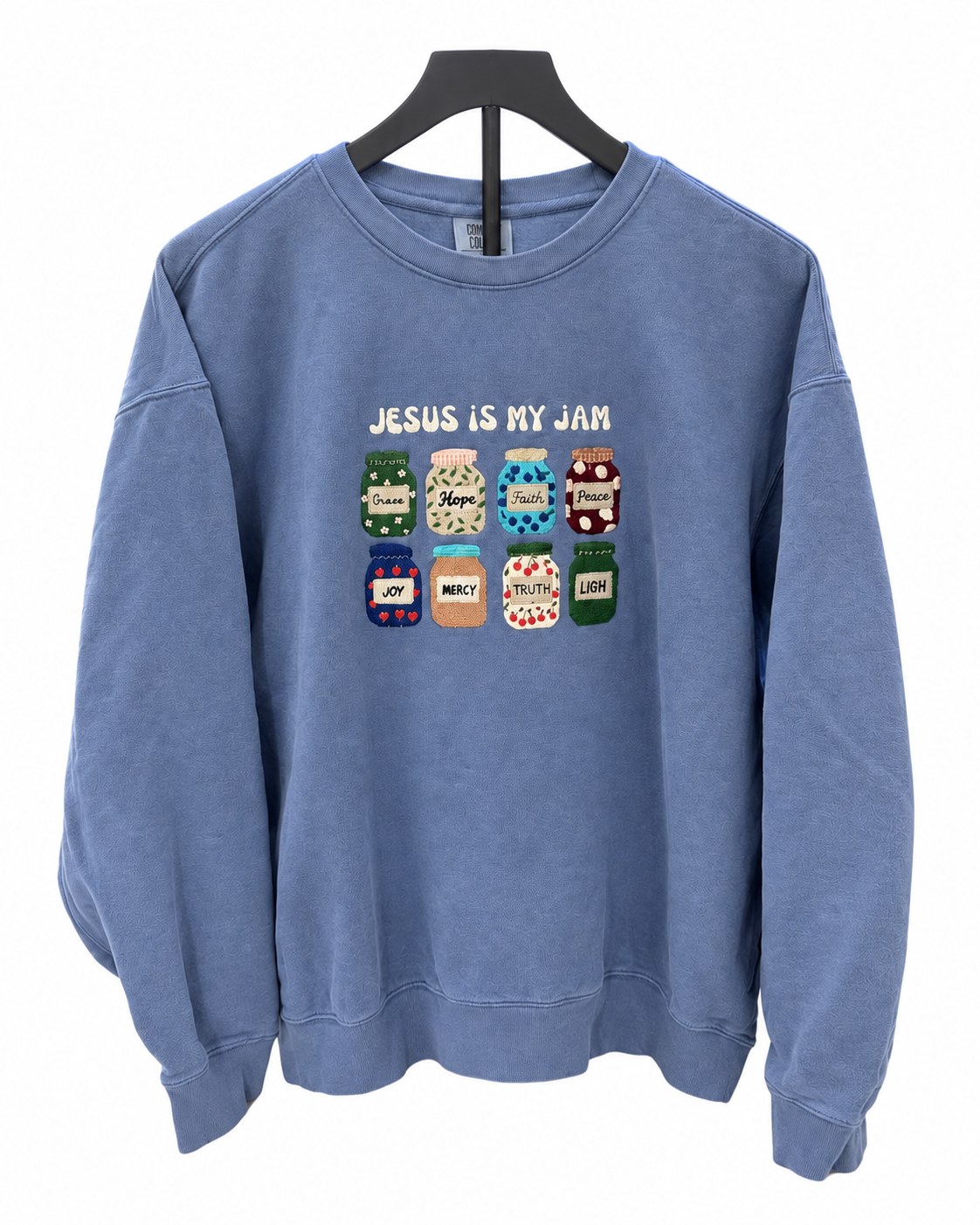 Blue sweatshirt embroidered with Jesus Is My Jam and eight jam jars