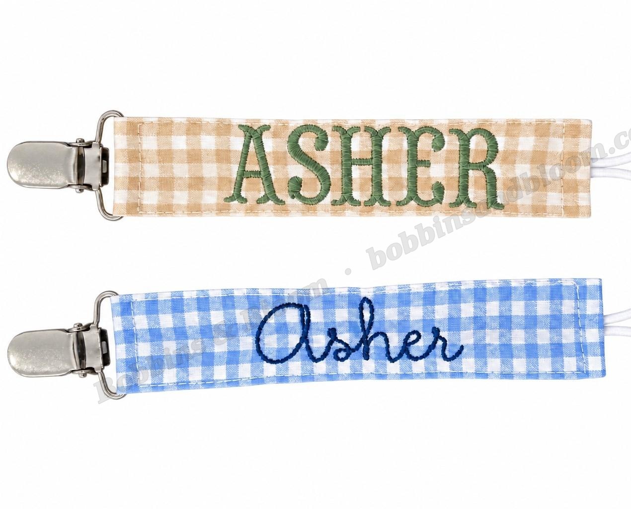 Two embroidered gingham paci clips personalized with the name Asher